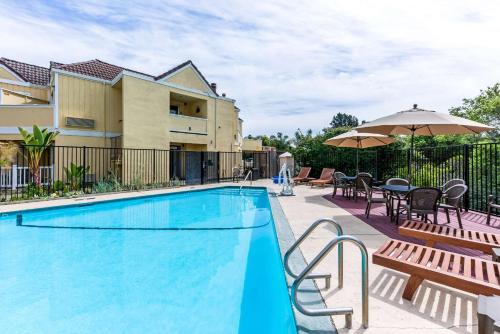 卡皮托拉卡皮托拉优质酒店及套房的一座带桌椅的游泳池位于酒店大楼旁