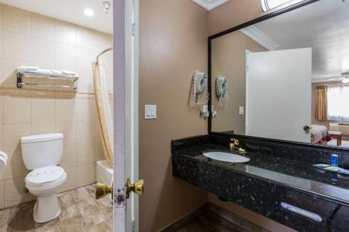 赛普里斯赛普拉斯罗德威旅馆的一间带卫生间、水槽和镜子的浴室
