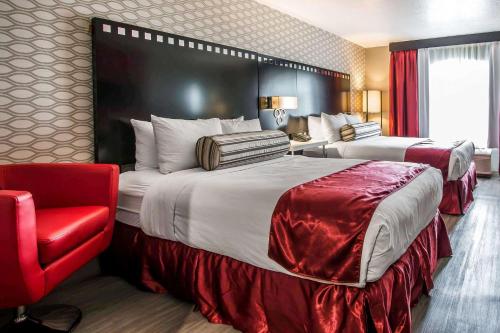 洛杉矶Tilt Hotel Universal/Hollywood, Ascend Hotel Collection的酒店客房,设有两张床和一张红色椅子