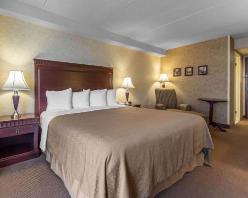 苏圣玛丽湾前区品质套房酒店的酒店客房带一张大床和一把椅子