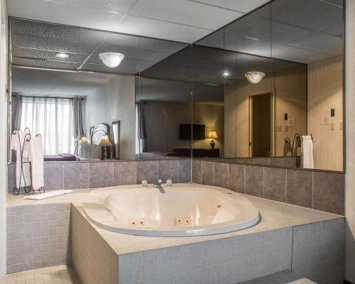 伍德斯托克伍德斯托克品质套房酒店的一个带大镜子的浴室内的大浴缸