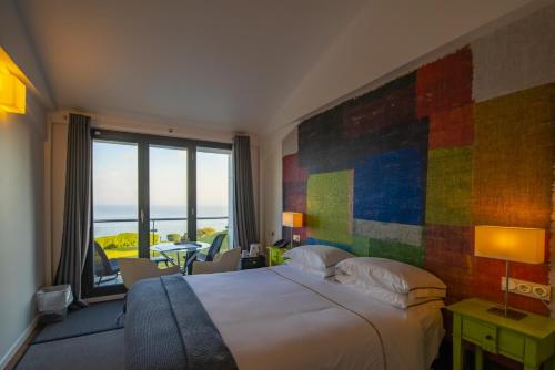 穆特里库Hotel Arbe的一间卧室设有一张大床和色彩缤纷的墙壁