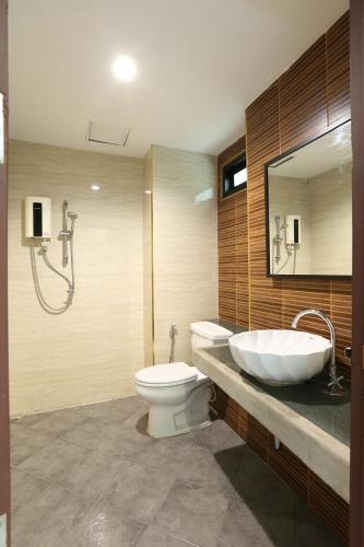 乔木提恩海滩阳光酒店的一间带水槽、卫生间和镜子的浴室