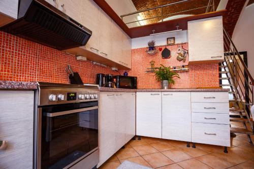 蒂米什瓦拉OLD SQUARE APARTMENTS 3的厨房配有白色橱柜和砖墙