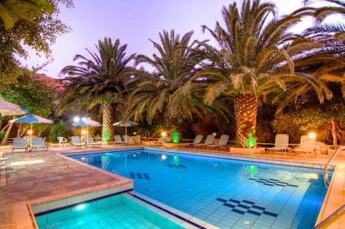 罗达奇诺Sunrise Hotel & Apartments的度假村内棕榈树游泳池