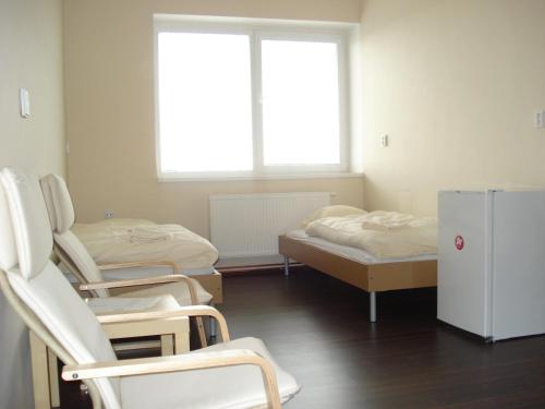 Rouchovany罗霍姆瓦尼住宅区酒店的客房设有三张床、椅子和冰箱。