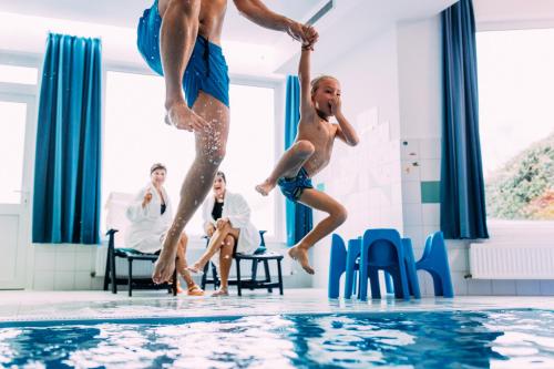 皮茨河谷阿兹尔Pitzis Kinderhotel - Family Only的两个男人跳进游泳池