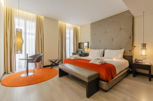 里斯本圣塔胡斯塔酒店的一间卧室配有一张带红色毯子的大床
