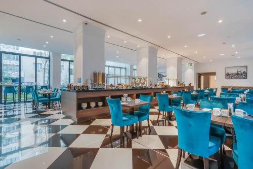 布达佩斯布达佩斯多瑙河欧洲之星酒店的一间设有蓝色椅子的餐厅和一间酒吧