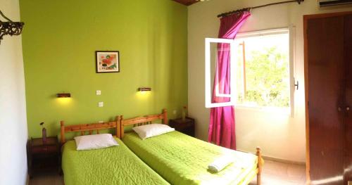 卡沃斯Ionian Breeze Apartments的绿色卧室设有两张床,配有窗户