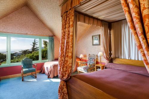 但尼丁城堡稳定住宿＆拉纳克山林小屋的一间卧室设有一张床和一个大窗户
