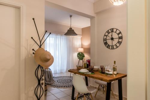 雅典Acropolis, Urban Lifestyle apartment的一间设有桌子和墙上时钟的餐厅