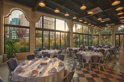 安曼豪斯精品套房酒店的宴会厅配有桌椅和窗户