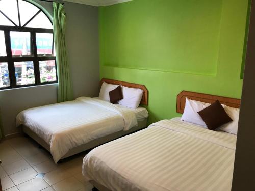 瓜拉江沙康萨尔酒店 的绿墙客房内的两张床
