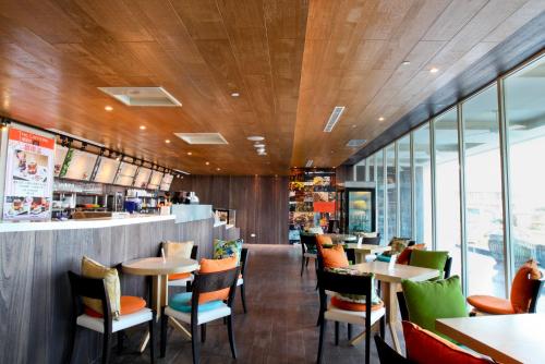 万里区薆悦酒店野柳渡假馆的餐厅设有木制天花板和桌椅