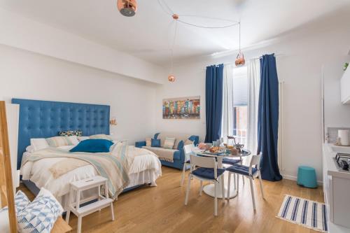 索伦托Monolocale Casa Pepe Sorrento的一间卧室配有一张蓝色的床和一张桌子