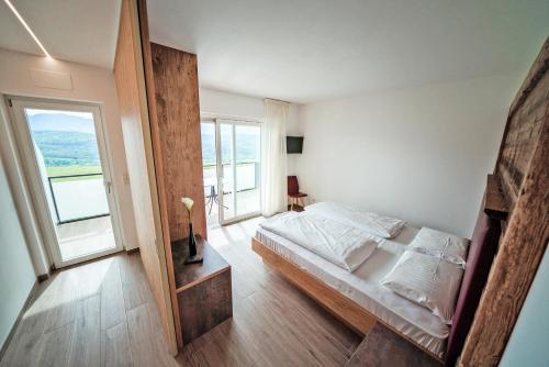 卡尔达罗Residence Tannhof的一间卧室设有一张床和一个大窗户
