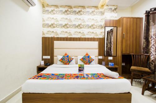 阿姆利则FabHotel Royal Villa Hussainpura Chowk的酒店客房,配有两张床和椅子