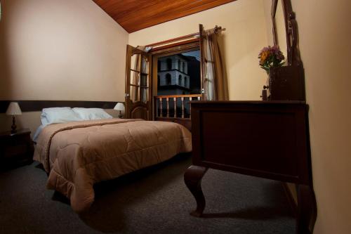 乌鲁班巴Yucay Plaza Inn的一间卧室配有一张大床和镜子