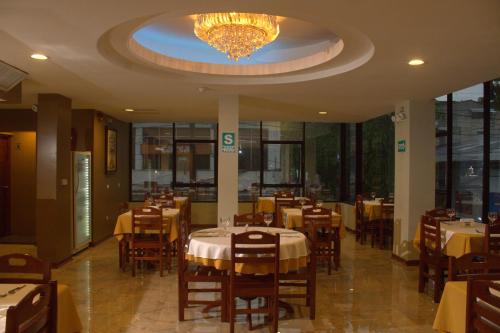 伊基托斯Hotel Europa的一间带桌椅和吊灯的餐厅