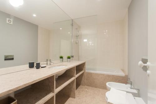里斯本FLH Principe Real Luxus Apartments的浴室配有盥洗盆、卫生间和浴缸。