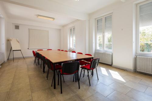 圣迪济耶尚巴尼酒店的一间会议室,配有木桌和红色椅子