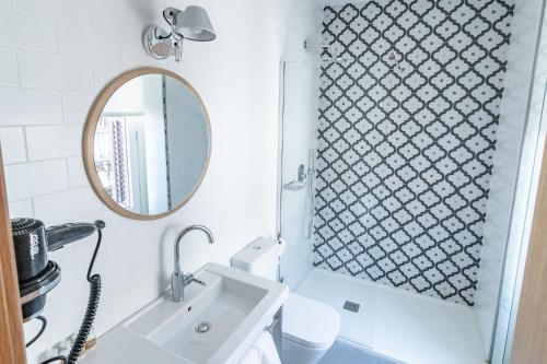马德里Plaza Mayor Suites & Apartments的一间带水槽和镜子的浴室