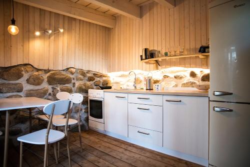 帕普帕普罗加斯山林小屋的厨房配有白色橱柜和桌椅