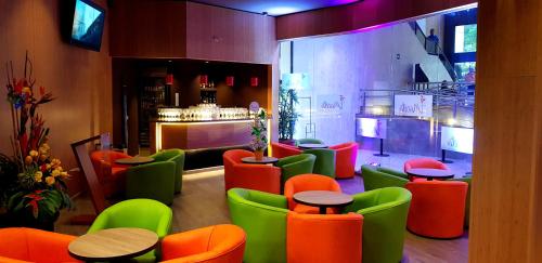 卡利托雷卡利广场酒店的一间设有五颜六色桌椅的餐厅和一间酒吧