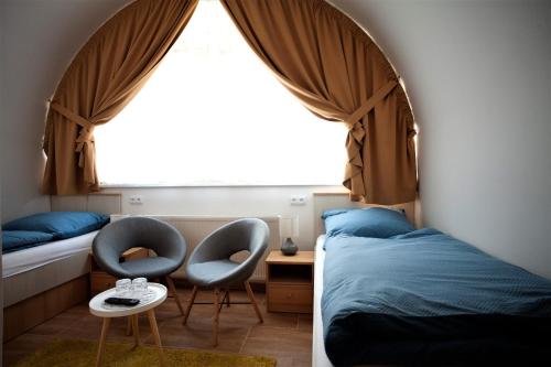 玛丽亚温泉Penzion u Pidly的一间卧室设有两张床、两把椅子和窗户。