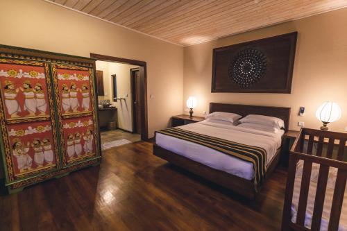 坦加拉阿迦瑟夫风景度假屋的卧室配有一张床,墙上挂有绘画作品