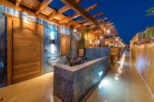 罗德镇10GR Boutique Hotel & Wine Bar的室外酒吧设有石墙和木制天花板