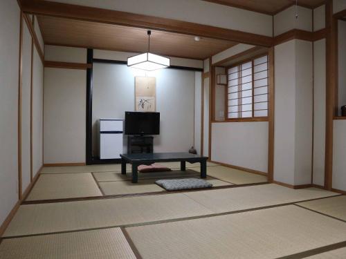 广岛Kimatsu Ryokan的配有电视和桌子的房间