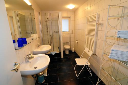 鲁斯特Ferienwohnungen Schmider的一间带两个盥洗盆、淋浴和卫生间的浴室