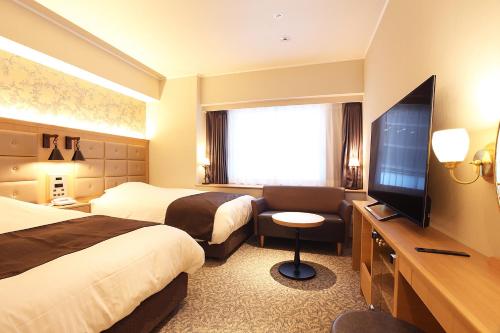 神户神户三宫酒店的酒店客房设有两张床和一台平面电视。