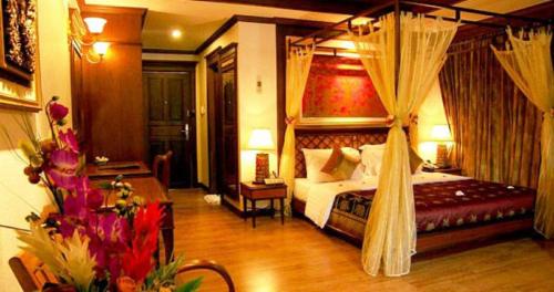皮皮岛皮皮岛棕榈树度假酒店的一间卧室配有一张带天蓬的床