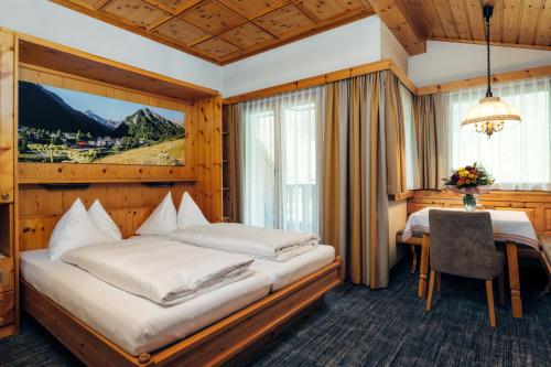 萨姆瑙恩恩加丁疗养酒店的酒店客房设有两张床和一张桌子。