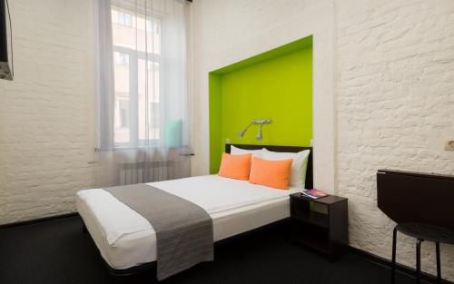 圣彼得堡S13站酒店的一间卧室配有一张大床和绿色床头板