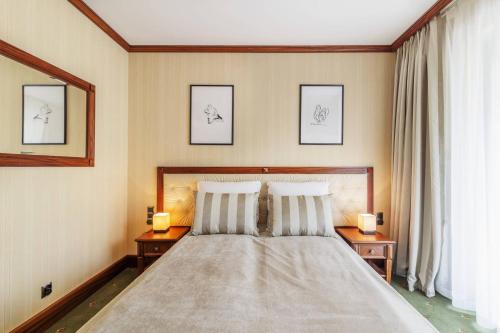索波特Prestige Apartment with Sauna by Grand Apartments的一间卧室配有一张床,两台桌子上放着两盏灯