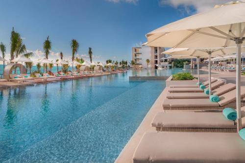 坎昆Haven Riviera Cancun - All Inclusive - Adults Only的一个带躺椅和遮阳伞的游泳池