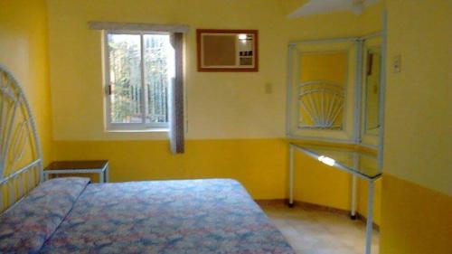 特米斯科HOTEL POSADA MONTSERRAT的黄色的卧室设有床和窗户
