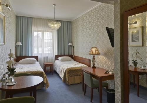 比亚瓦波德拉斯卡斯卡拉酒店的酒店客房带两张床和一张桌子以及椅子。