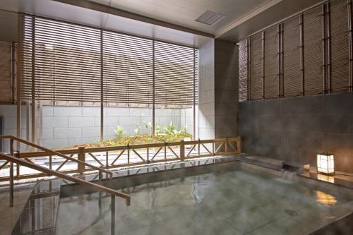 京都京阪京都八条口酒店的一间带大窗户和浴缸的浴室