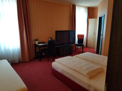 科伯恩-贡多夫Hotel Haupt的酒店客房配有一张床、一张书桌和一台电视。