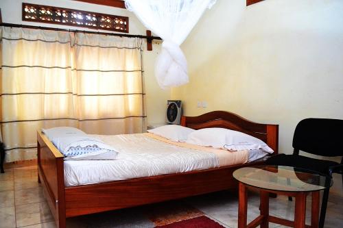 恩德培Eco Resort Kasenyi的卧室配有床、椅子和窗户。