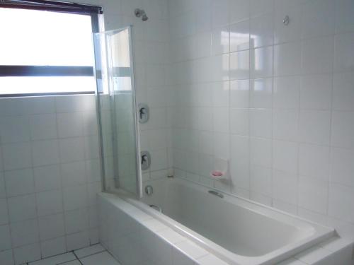 姆巴巴内Liz' Cottage的白色的浴室设有浴缸和窗户。