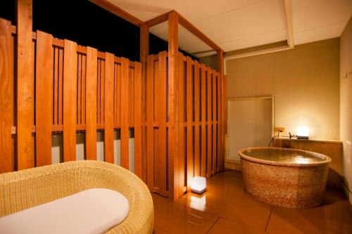 伊势市伊势市伊势神宫酒店的一间带浴缸的浴室,位于一个木墙客房内