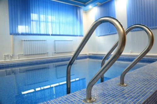 休钦斯克Bereke Hotel的游泳池旁的带金属扶手的游泳池