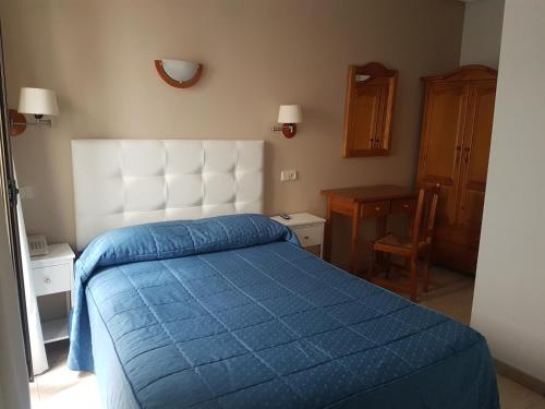 托莱多中心旅馆的一间卧室配有一张蓝色的床和白色床头板