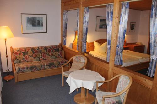 Hemfurth-Edersee多恩罗森索瓦尔德霍特尔酒店的一间卧室配有一张双层床、一张沙发和一张桌子。